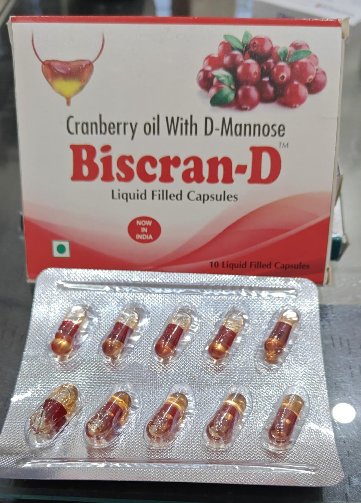 Biscran-D capsule box and packaging, an oil-based Cranberry Oil, D-Mannose, and Tea Tree Oil liquid-filled capsule for UTI prophylaxis by Bon Apress Pharma.